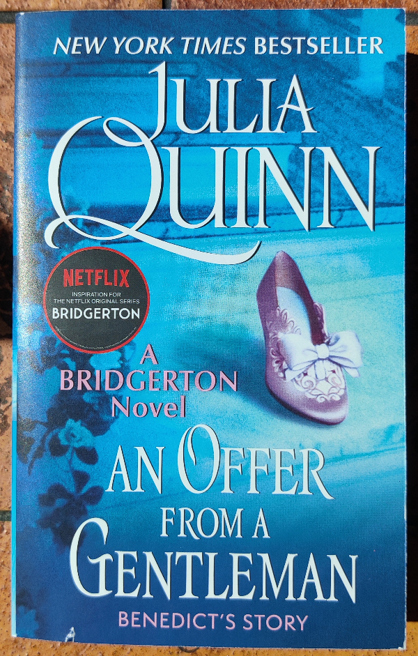 Cover of An Offer from a Gentleman by Julia Quinn. The background  is blue and features a pink shoe with a jeweled bow and clip. 